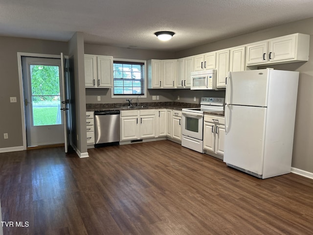 608 Walnut St, Elizabethton, TN 37643 - kitchen with white appliances, a sink, dark countertops, dark wood-style flooring, and white cabinets