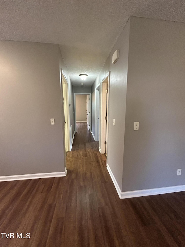 608 Walnut St, Elizabethton, TN 37643 - corridor featuring dark wood finished floors, baseboards, and a textured ceiling