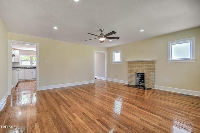 350 Texas Ave, Bristol, VA 24201 - unfurnished living room with a ceiling fan, visible vents, a fireplace, light wood-type flooring, and baseboards