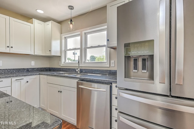 350 Texas Ave, Bristol, VA 24201 - kitchen featuring wood finished floors, white cabinets, a sink, hanging light fixtures, and stainless steel appliances