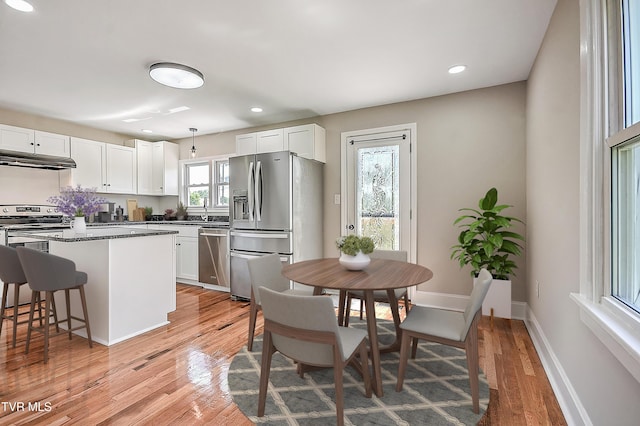 350 Texas Ave, Bristol, VA 24201 - kitchen with baseboards, under cabinet range hood, white cabinets, light wood finished floors, and appliances with stainless steel finishes