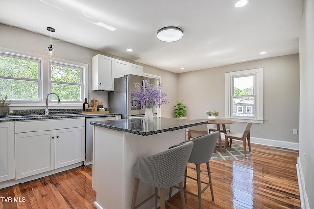 350 Texas Ave, Bristol, VA 24201 - kitchen with a sink, light wood finished floors, a breakfast bar area, dark stone countertops, and stainless steel appliances