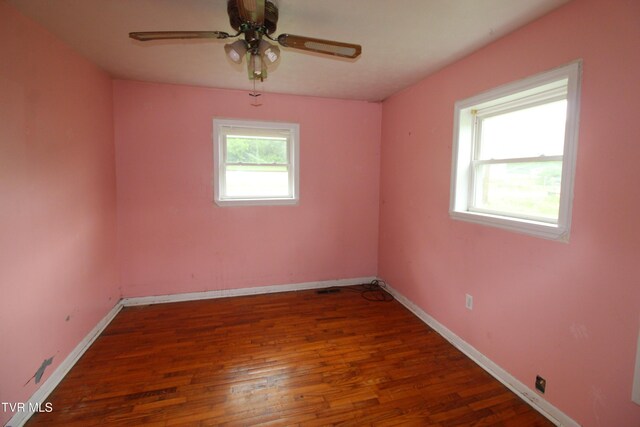 spare room featuring baseboards, ceiling fan, and wood finished floors
