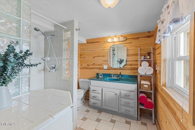 196 Furches Dr, Gray, TN 37615 - full bathroom with wooden walls, a tile shower, plenty of natural light, a textured ceiling, and vanity