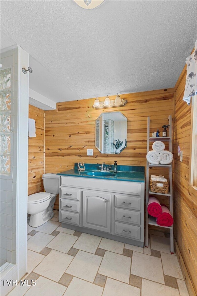 196 Furches Dr, Gray, TN 37615 - bathroom featuring wooden walls, vanity, a textured ceiling, toilet, and a shower