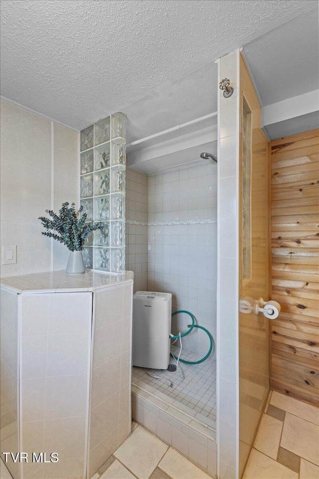 196 Furches Dr, Gray, TN 37615 - bathroom with tile patterned floors, tile walls, walk in shower, and a textured ceiling