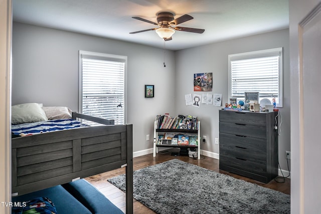 bedroom with ceiling fan, baseboards, and wood finished floors