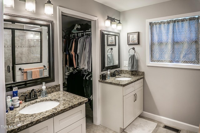 full bath with a spacious closet, visible vents, and a sink