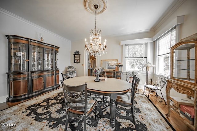 dining room with crown molding, a chandelier, and light wood finished floors