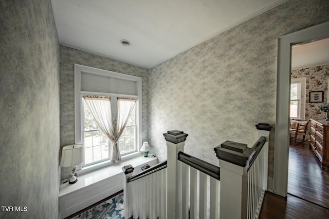 interior space with crown molding, wallpapered walls, visible vents, and wood finished floors