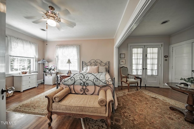bedroom with crown molding, wood finished floors, and visible vents