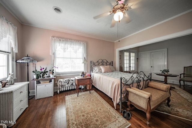 bedroom featuring multiple windows, ornamental molding, visible vents, and dark wood-type flooring