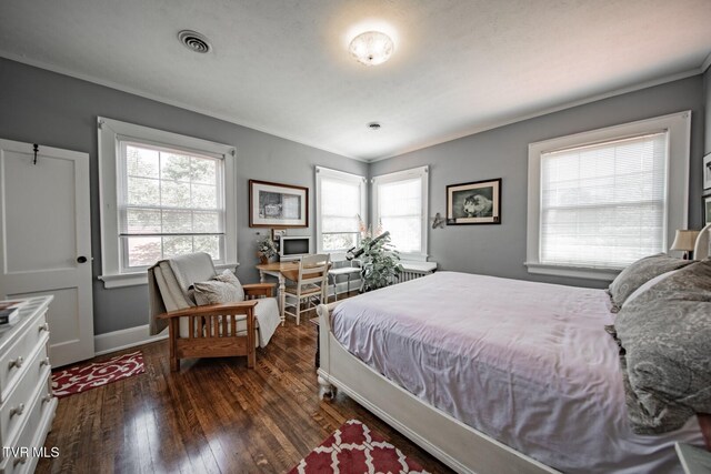 bedroom featuring crown molding, visible vents, dark wood-style floors, and multiple windows
