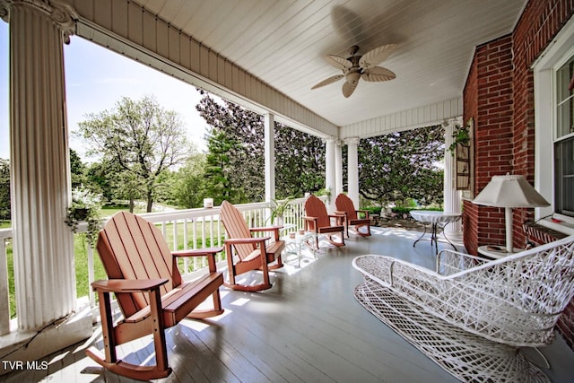 wooden terrace featuring covered porch and a ceiling fan