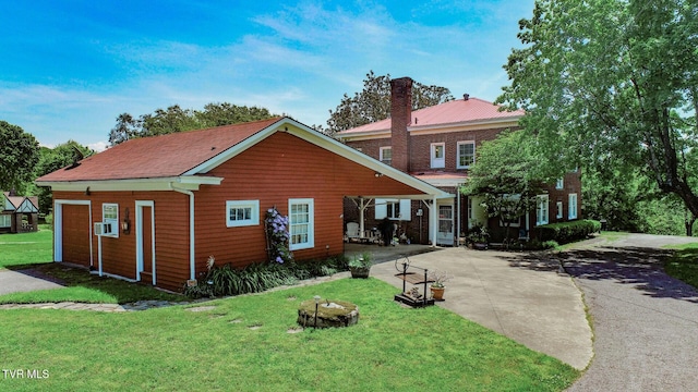 view of front of house featuring a chimney, a front yard, and concrete driveway