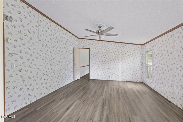 269 Rocky Branch Rd, Elizabethton, TN 37643 - unfurnished living room featuring crown molding, wallpapered walls, wood finished floors, a ceiling fan, and a textured ceiling