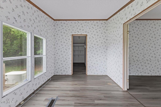 269 Rocky Branch Rd, Elizabethton, TN 37643 - spare room featuring ornamental molding, wallpapered walls, wood finished floors, and baseboards