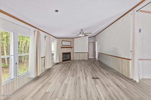 269 Rocky Branch Rd, Elizabethton, TN 37643 - unfurnished living room featuring ceiling fan, light wood-style flooring, plenty of natural light, crown molding, and a glass covered fireplace