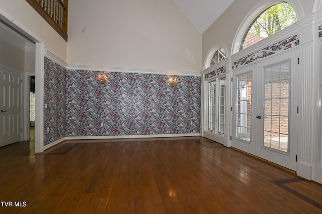 spare room with baseboards, french doors, wallpapered walls, and hardwood / wood-style floors
