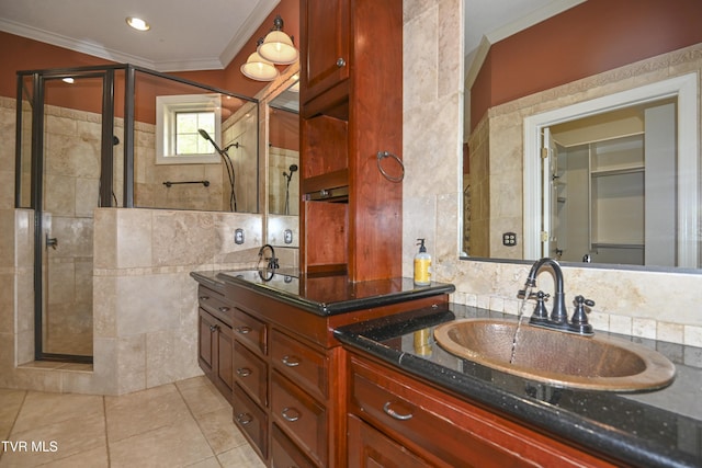 full bath with vanity, ornamental molding, tile walls, tile patterned floors, and a shower stall