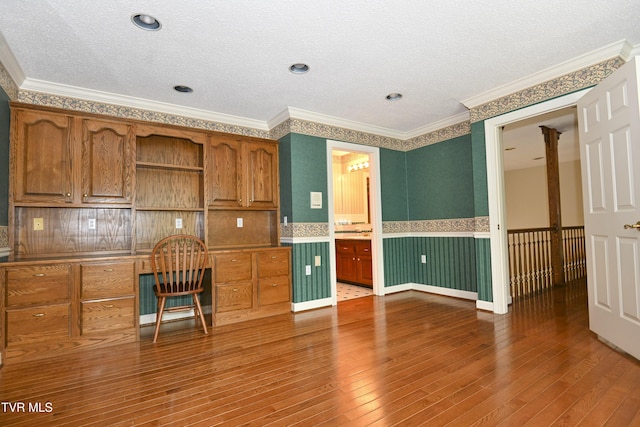 kitchen with wood-type flooring, ornamental molding, open shelves, a textured ceiling, and brown cabinets