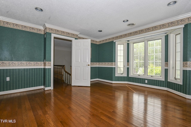 unfurnished room with hardwood / wood-style flooring and a wainscoted wall