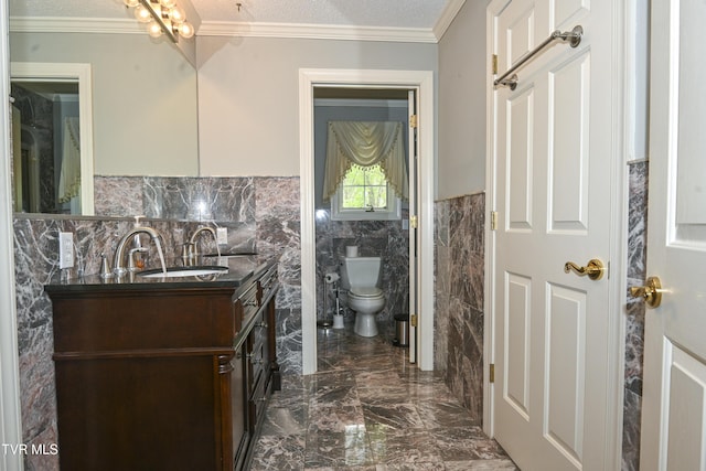 bathroom featuring wainscoting, vanity, toilet, marble finish floor, and tile walls