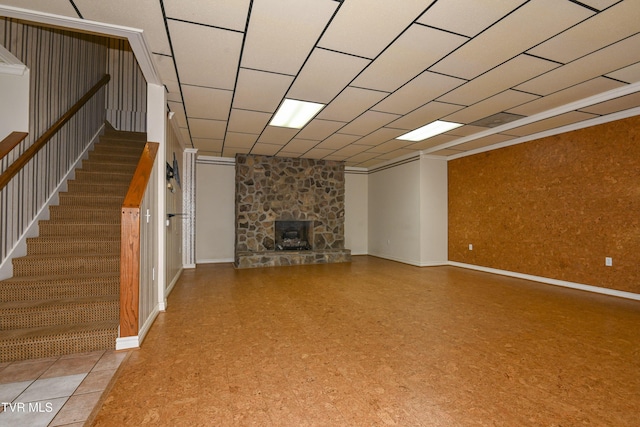 unfurnished living room featuring stairway, baseboards, and a stone fireplace