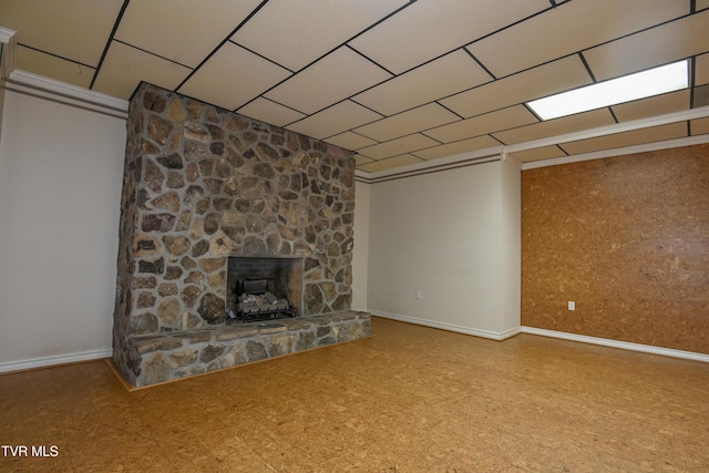 unfurnished living room with baseboards and a stone fireplace