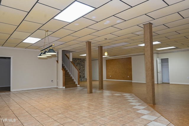 below grade area featuring stairs and baseboards