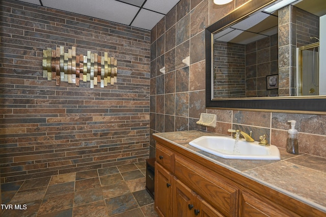 bathroom with vanity, a paneled ceiling, and a shower stall