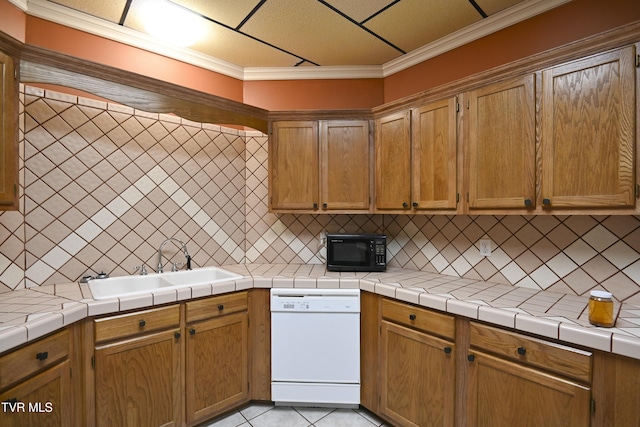 kitchen with black microwave, decorative backsplash, a sink, and dishwasher