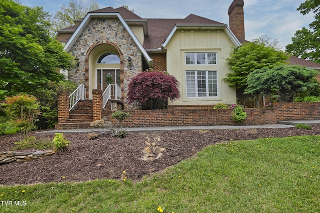 view of front of home with a chimney, a shingled roof, and stucco siding