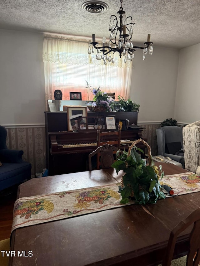 616 SE Kiser Ave, Coeburn, VA 24230 - dining room with an inviting chandelier, a textured ceiling, a wainscoted wall, and visible vents