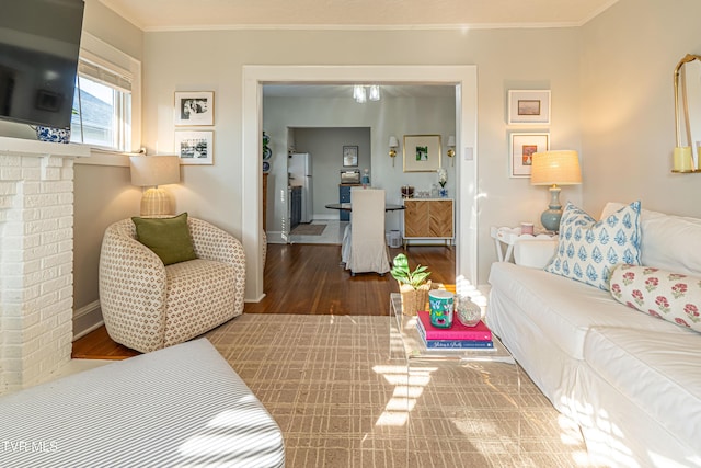 living area with baseboards, ornamental molding, and wood finished floors