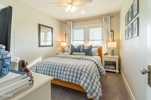bedroom with baseboards, a ceiling fan, a textured ceiling, and dark carpet