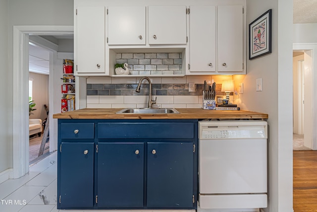 kitchen with a sink, blue cabinets, and dishwasher
