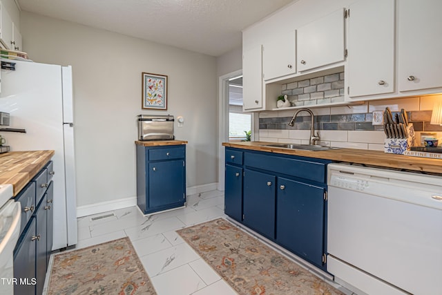 kitchen with a sink, blue cabinetry, white appliances, and butcher block countertops