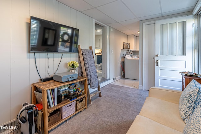 living area featuring washer / clothes dryer, carpet flooring, and a drop ceiling