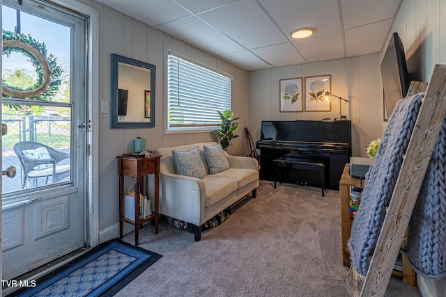 sitting room with carpet floors and a drop ceiling