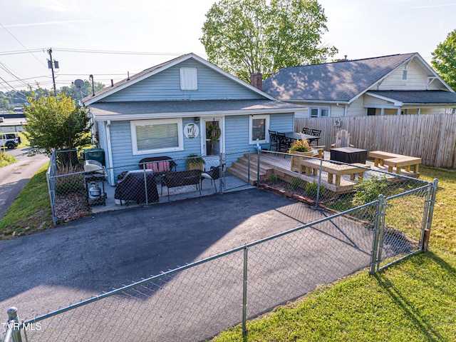bungalow with a gate, roof with shingles, a fenced backyard, and a deck