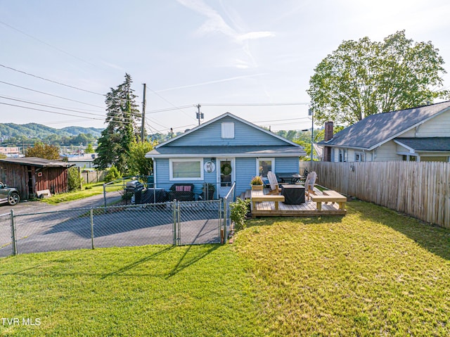 view of front of home featuring a deck with mountain view, a fenced backyard, and a front yard