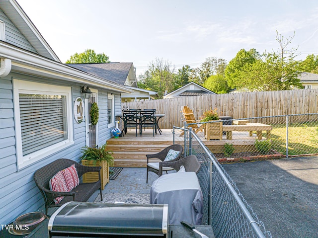 view of patio / terrace with a wooden deck, outdoor dining space, and a fenced backyard
