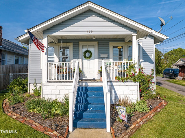 view of front of property with covered porch and fence