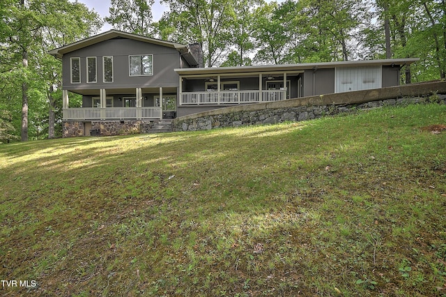 rear view of property featuring a yard, a porch, and a chimney