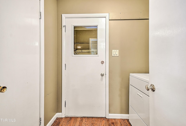 laundry area featuring washer / dryer, laundry area, wood finished floors, and baseboards