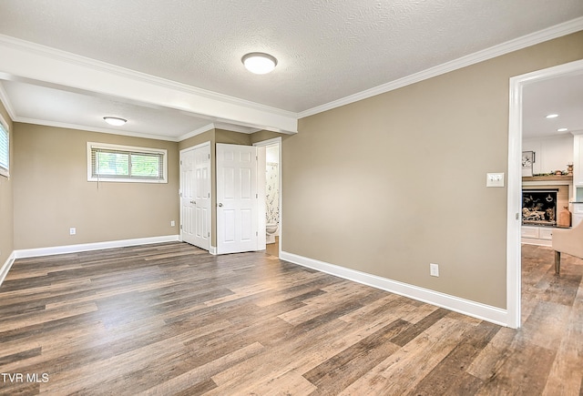 unfurnished bedroom with crown molding, baseboards, and wood finished floors