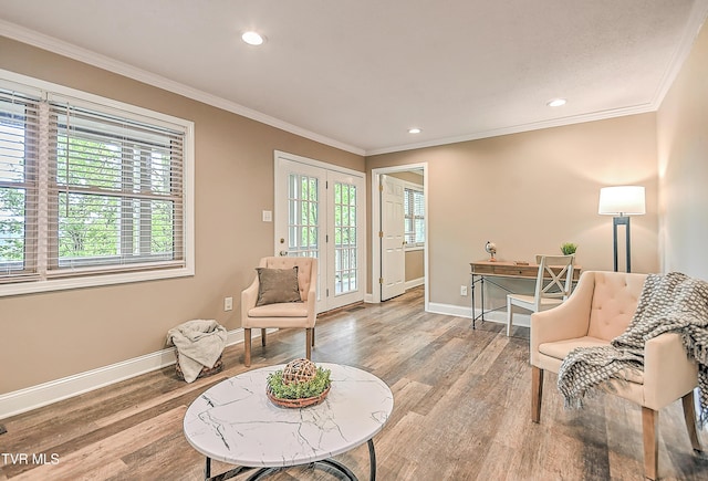 living area with baseboards, a healthy amount of sunlight, and wood finished floors