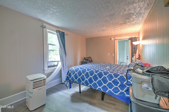 921 E Sevier Ave, Kingsport, TN 37660 - bedroom with baseboards, a textured ceiling, and wood finished floors