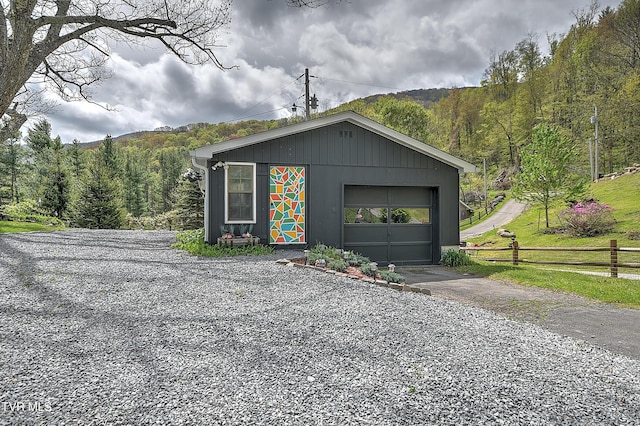 190 Roanwood Rd, Roan Mountain, TN 37687 - detached garage with fence, driveway, and a wooded view